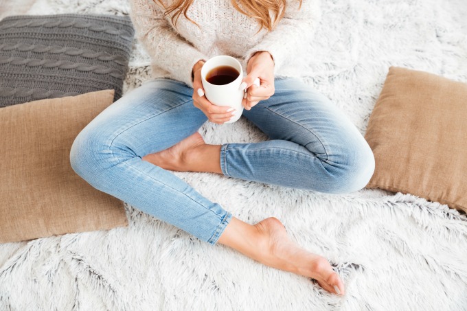 Lady sitting on rug with neutral pillows