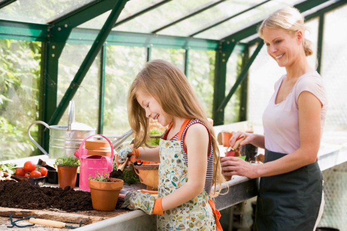 people transplanting plants with rich soil