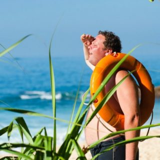 Average man at the beach with a life preserver