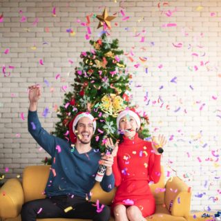 Couple celebrating in front of the Christmas tree