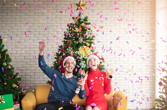 Couple celebrating in front of the Christmas tree