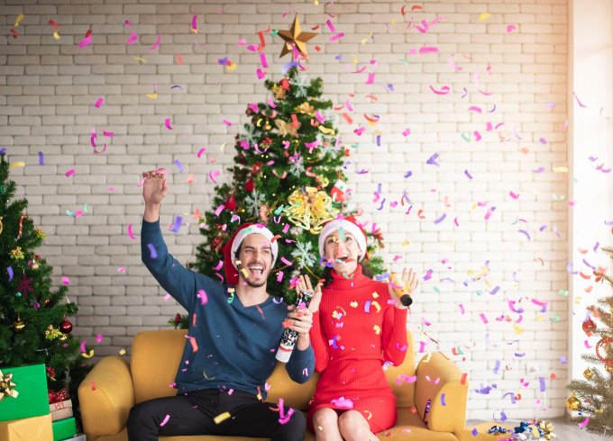 Couple celebrating in front of the Christmas tree