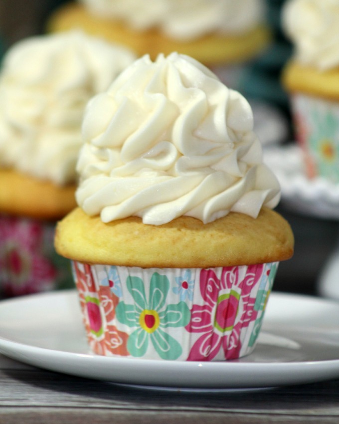 Champagne cupcake on a plate with more cupcakes in background