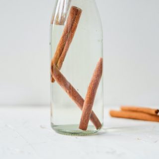 a clear bottle of vodka with cinnamon sticks