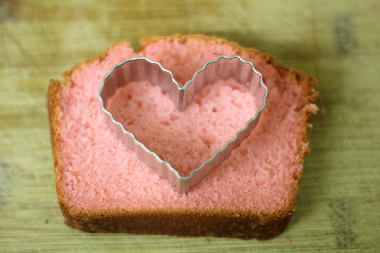 a slice of strawberry cake with a heart cookie cutter sitting on top