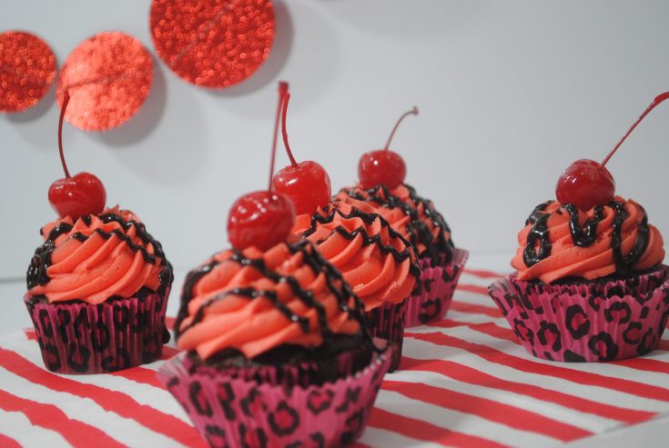 5 cupcakes sitting on a red and white striped placemat