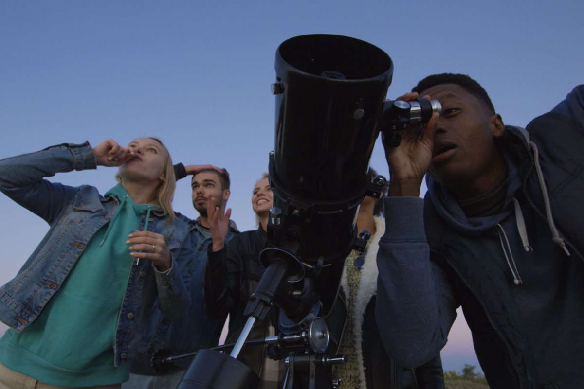 People looking through a high powered telescope