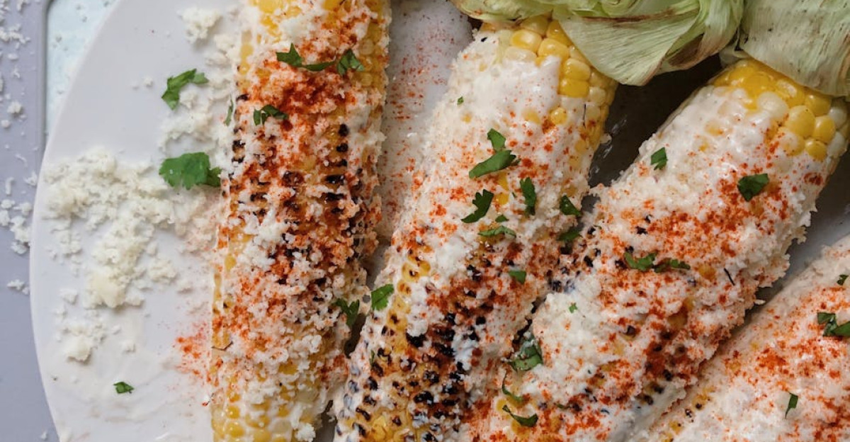 Close-up of seasoned Mexican street corn with cheese and chili flakes