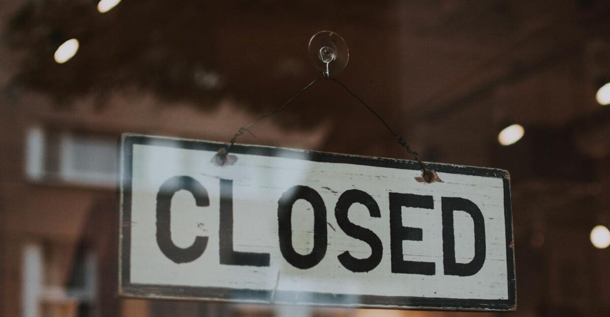 Classic closed sign hanging in front of a store window