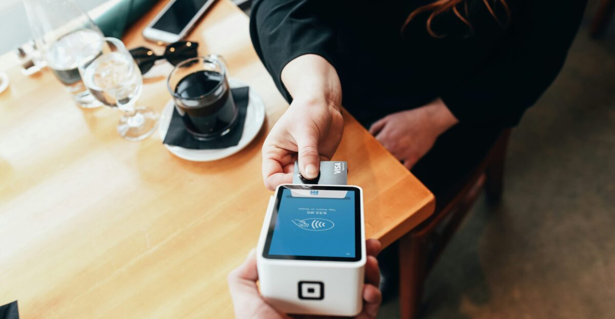 person holding credit card swipe machine