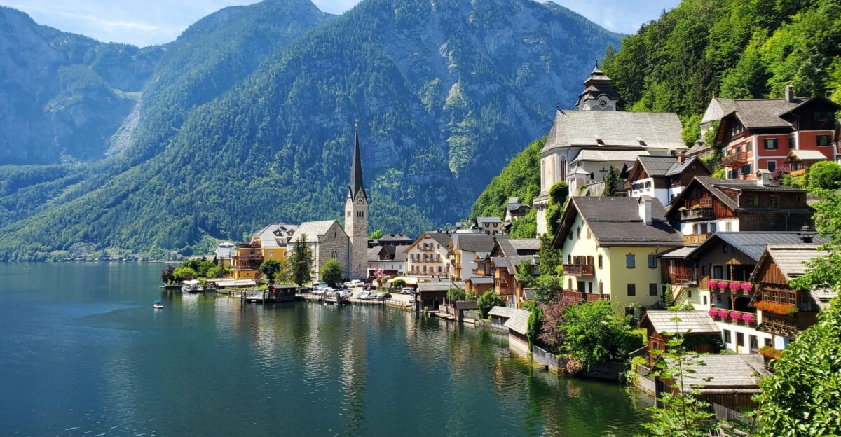 houses near body of water and mountain during daytime