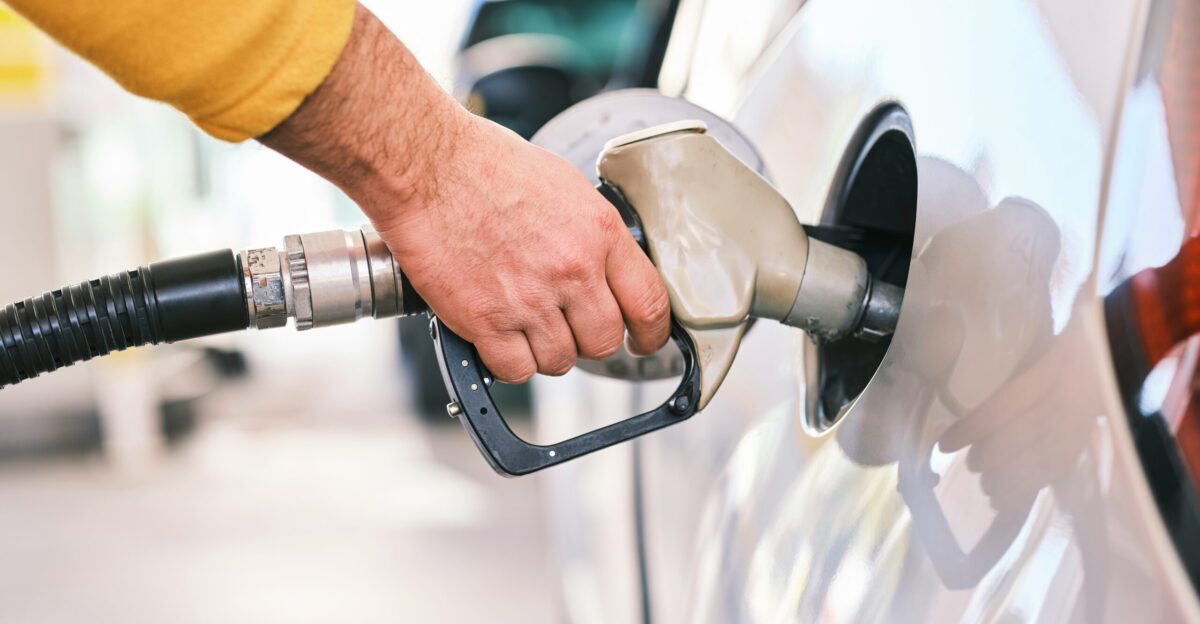 a man pumping gas into his car at a gas station