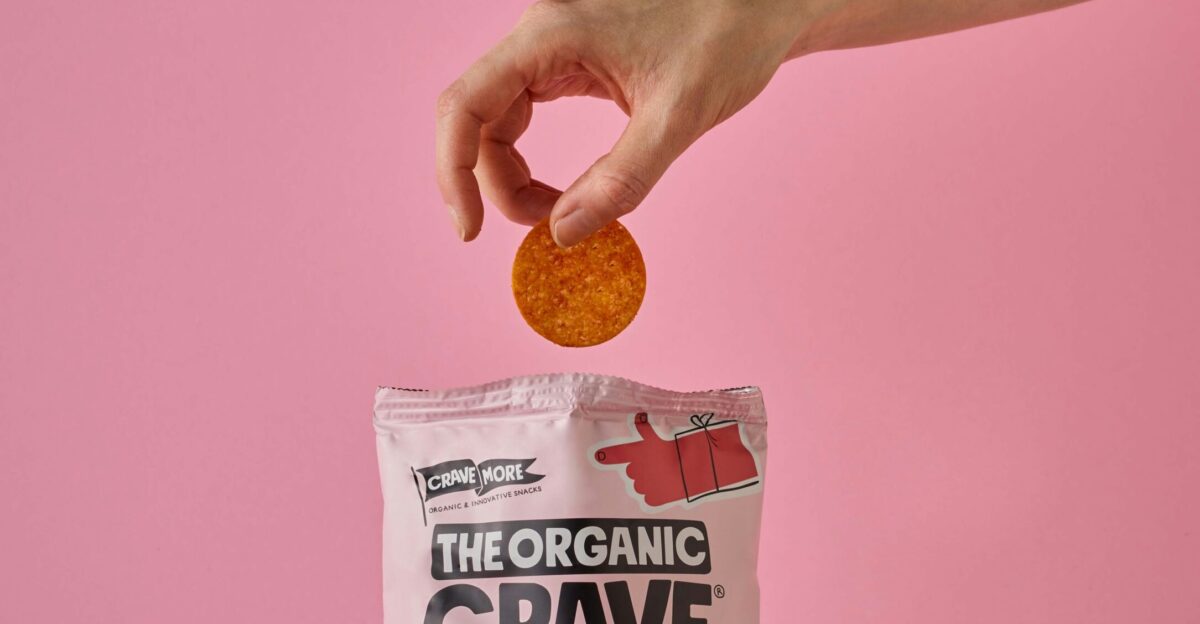 a bag of the organic crave protein chips on a pink background