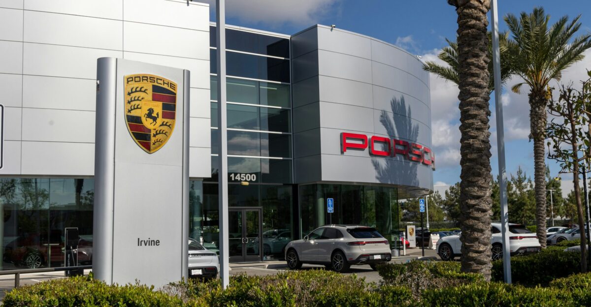 a porsche dealership with cars parked in front of it