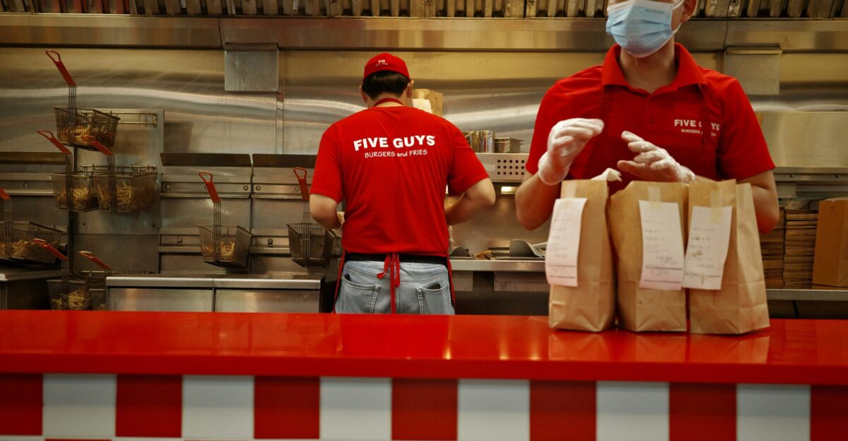 A man wearing a face mask standing behind a counter