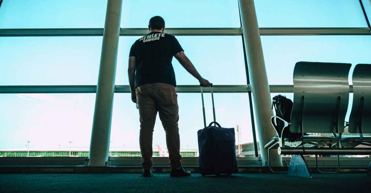 Man with luggage waiting at airport lounge anticipating departure in a modern setting