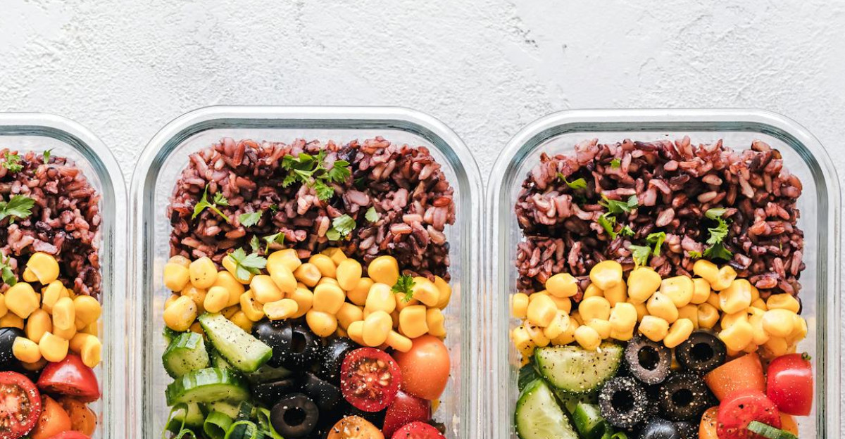 Colorful healthy meal prep with corn olives tomatoes and lentils in glass containers Perfect for mindful eating