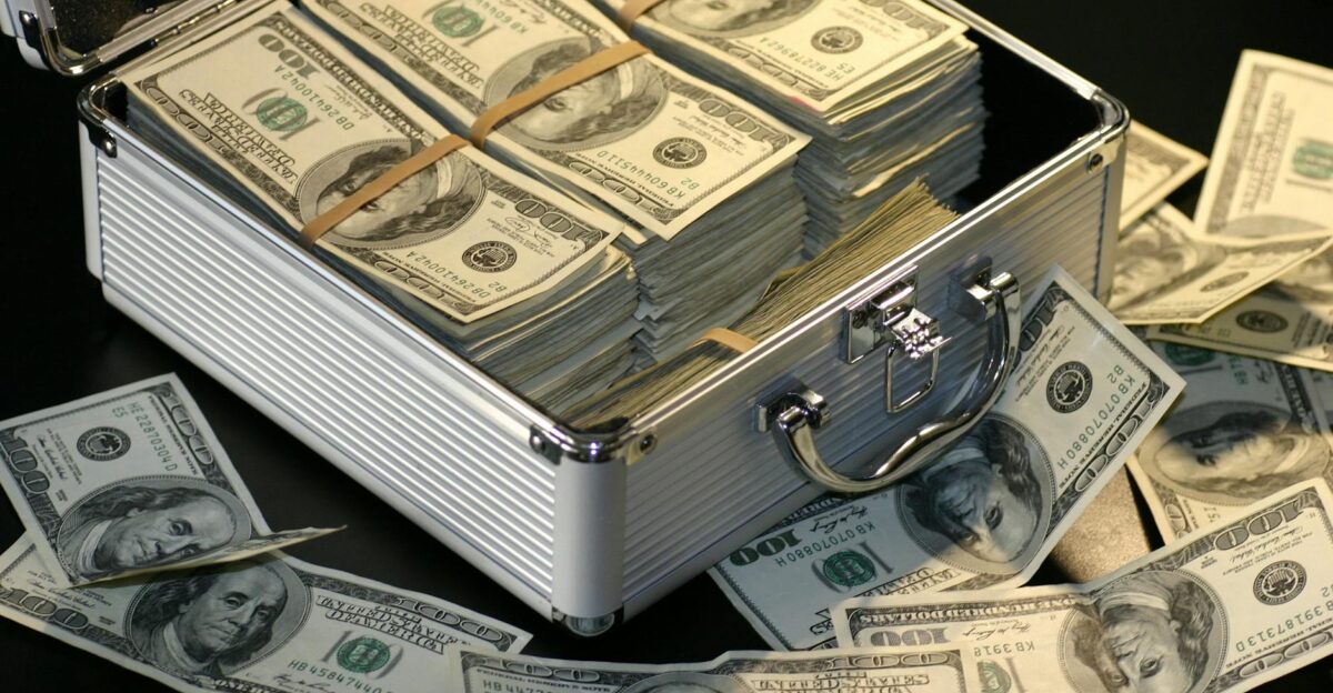 A metallic briefcase full of US dollar bills symbolizing wealth and investment