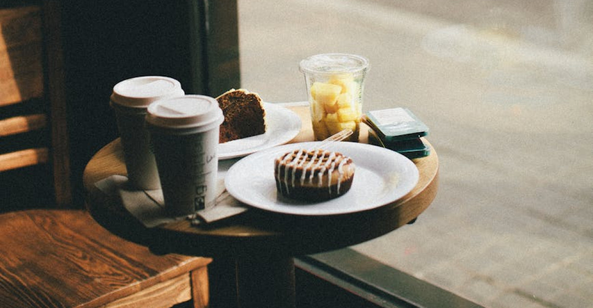 A tranquil coffee shop scene with coffee cups and pastries by a window