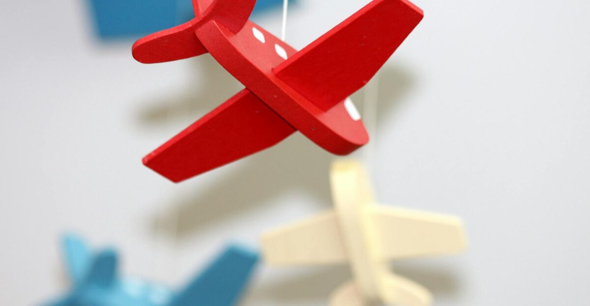 A close-up of colorful wooden airplane toys in a mobile perfect for nursery d cor
