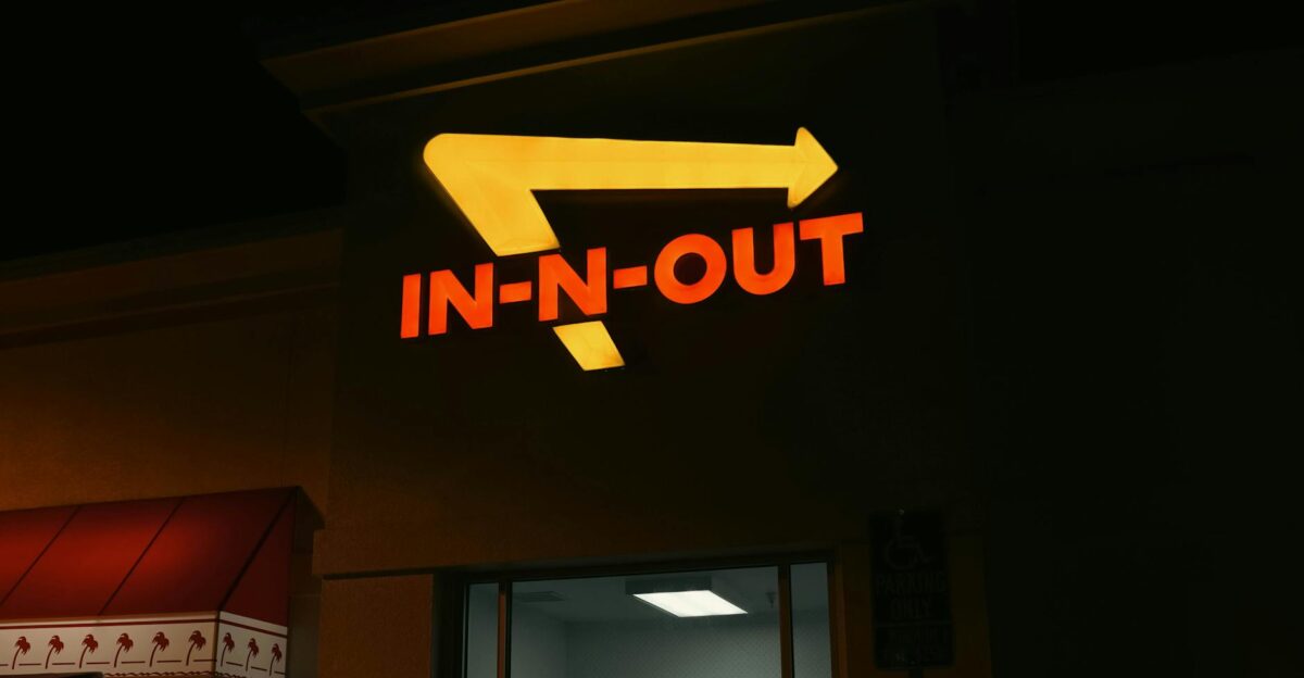 Bright neon In-N-Out sign glowing at night outside a restaurant in California