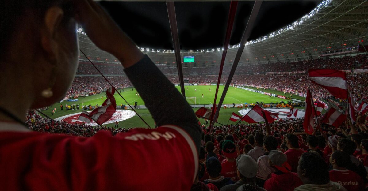 Lively soccer match at packed Brazilian stadium with cheering fans and vibrant atmosphere