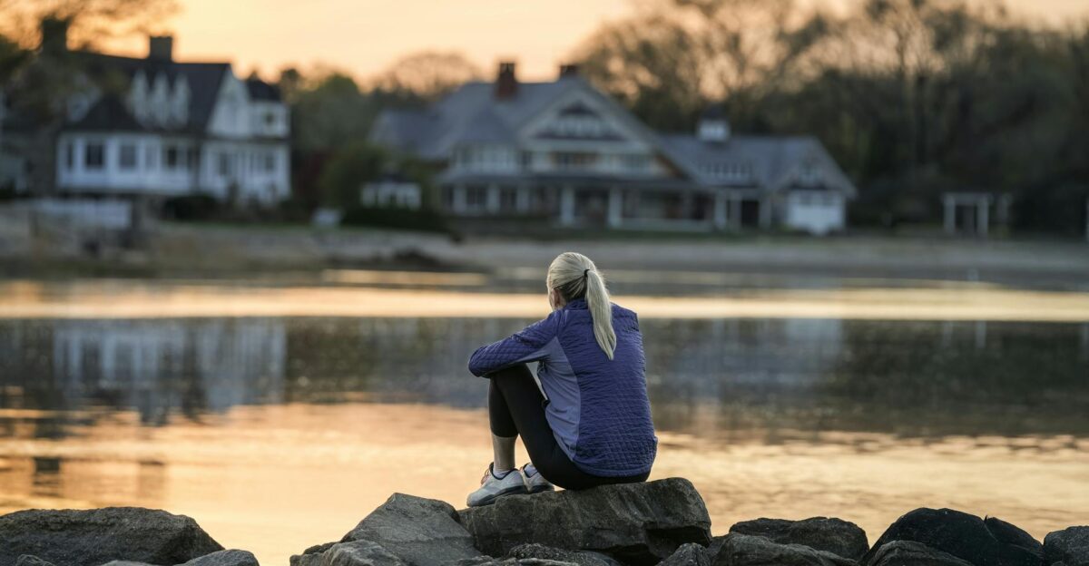 A person sits by the water at dawn in Cove Island Park Stamford Connecticut