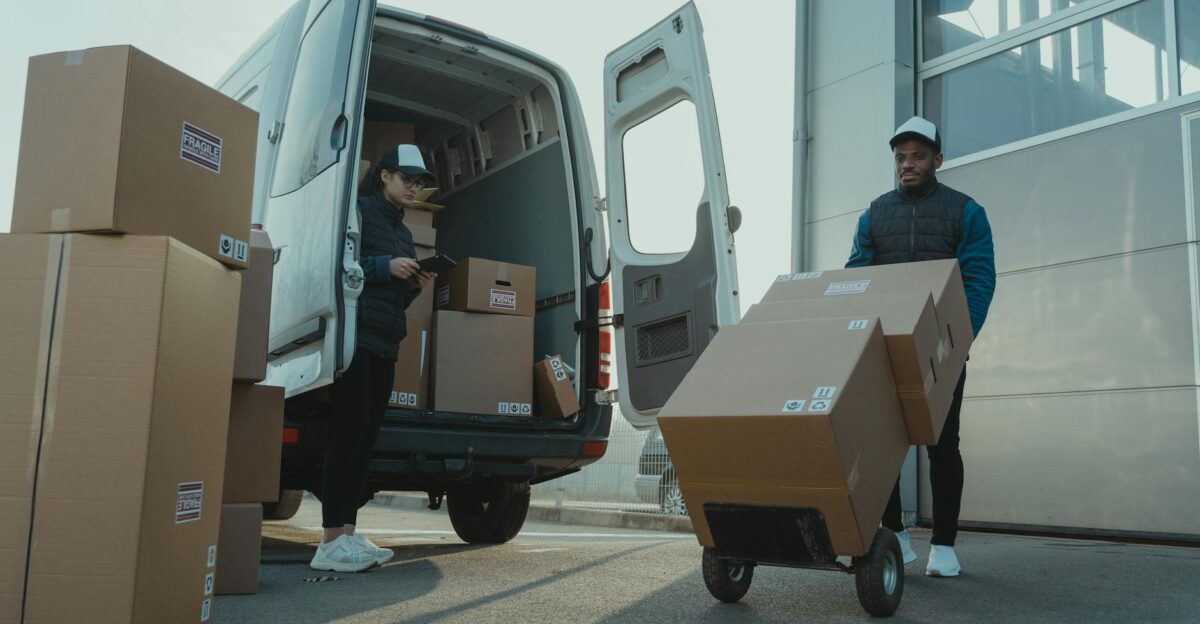 Two couriers load boxes into a van for shipment showcasing logistics and teamwork