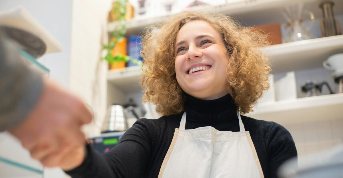 Smiling barista in caf engaging positively with customer signifying hospitality