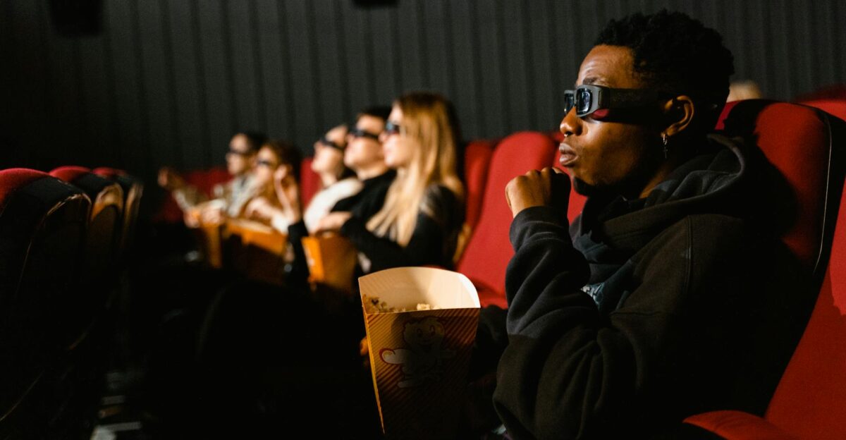 A group of diverse adults wearing 3D glasses enjoying a movie indoors