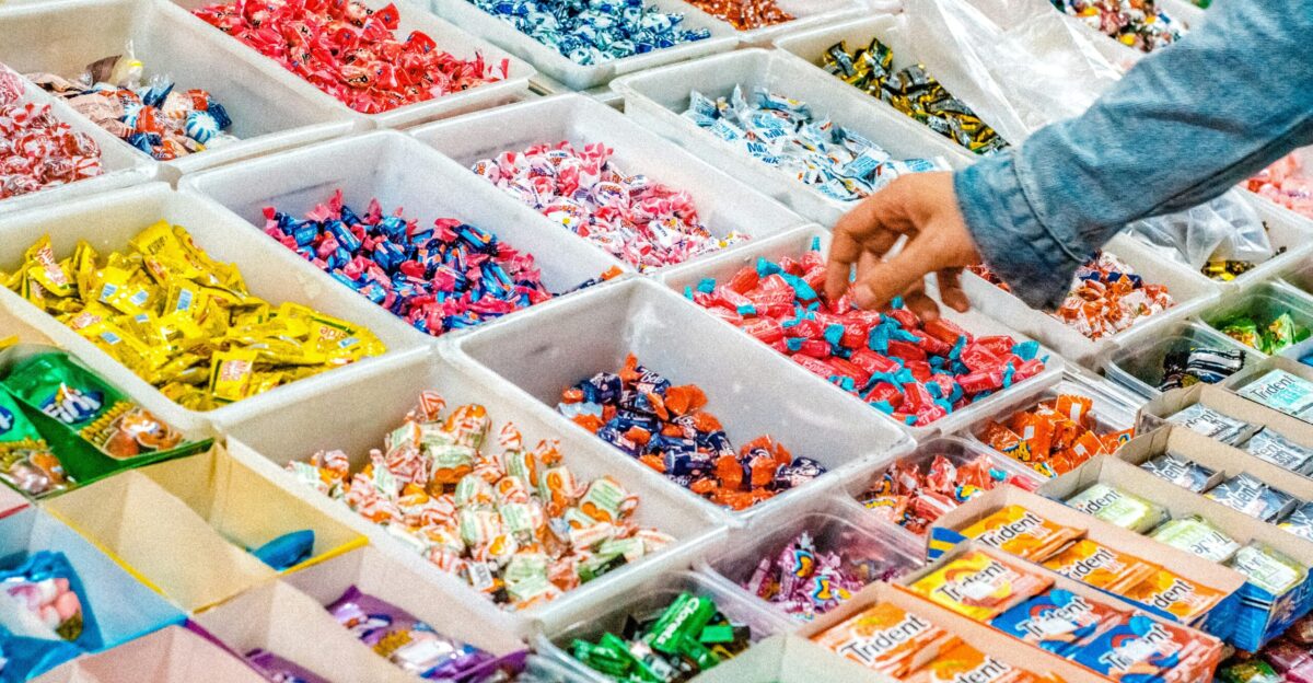 person holding a candy pack on white plastic box