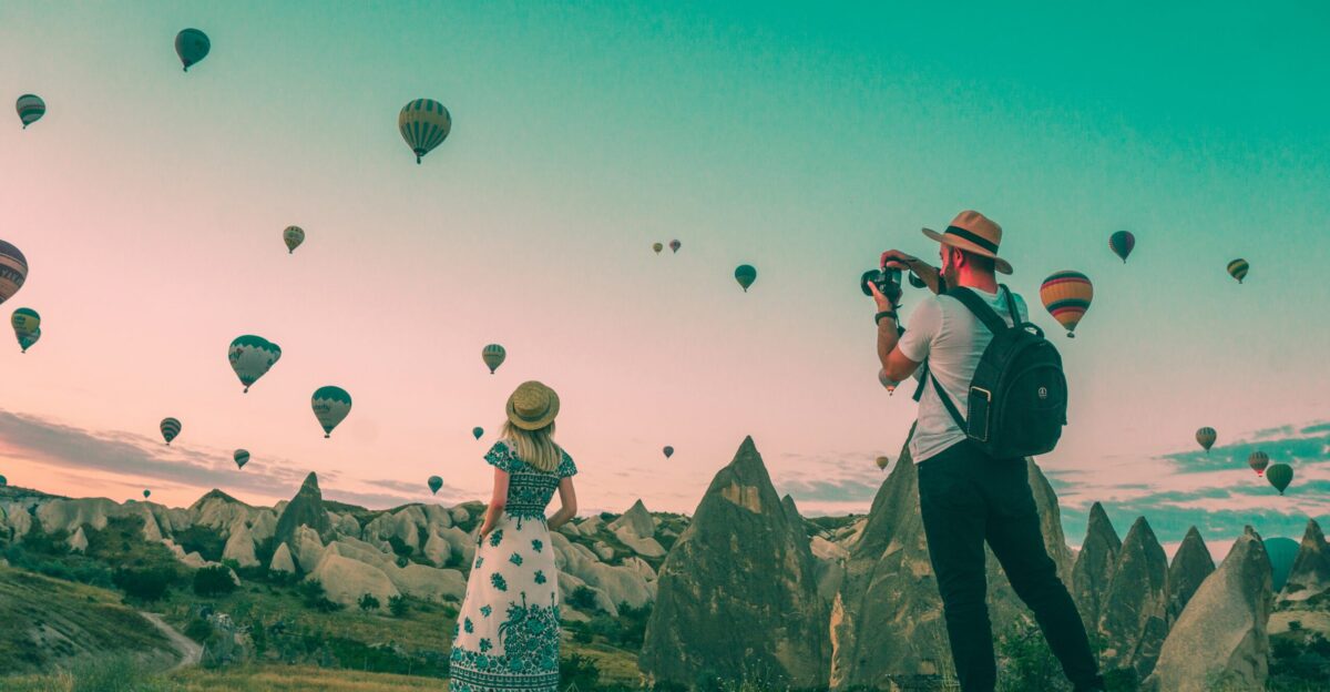 man taking photo of hot air balloons