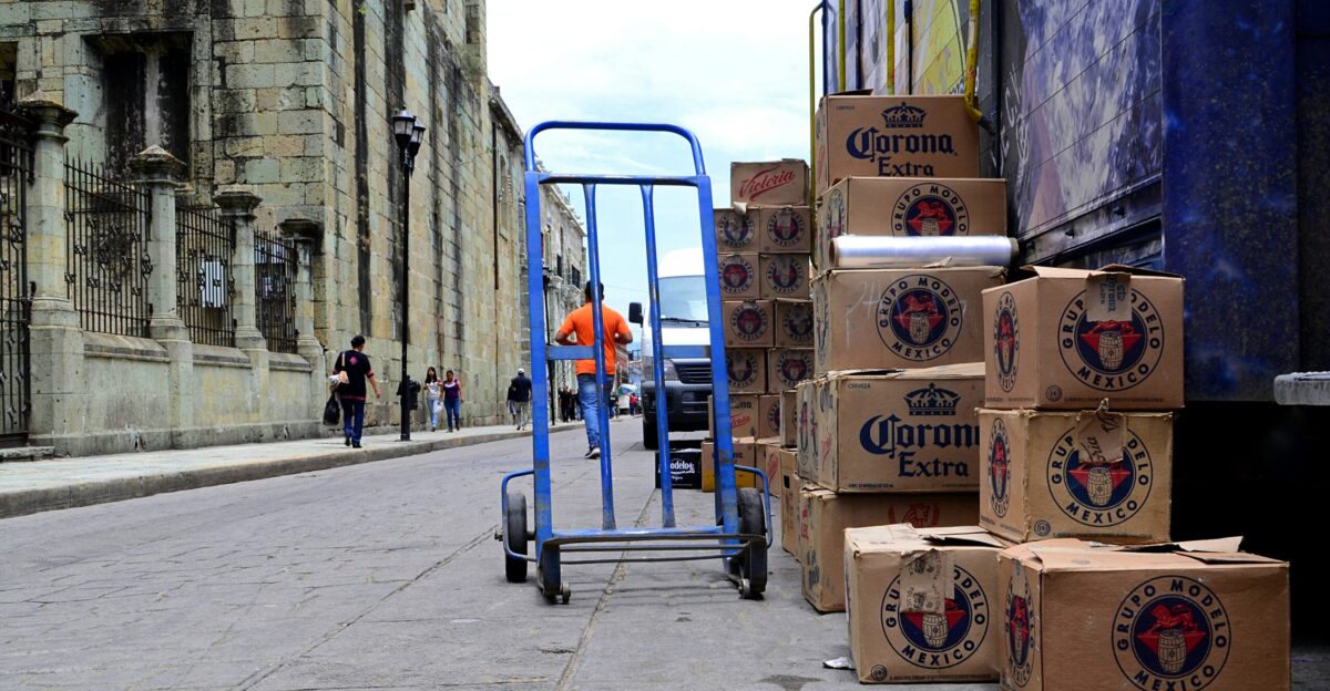 blue hand truck beside cardboard boxes