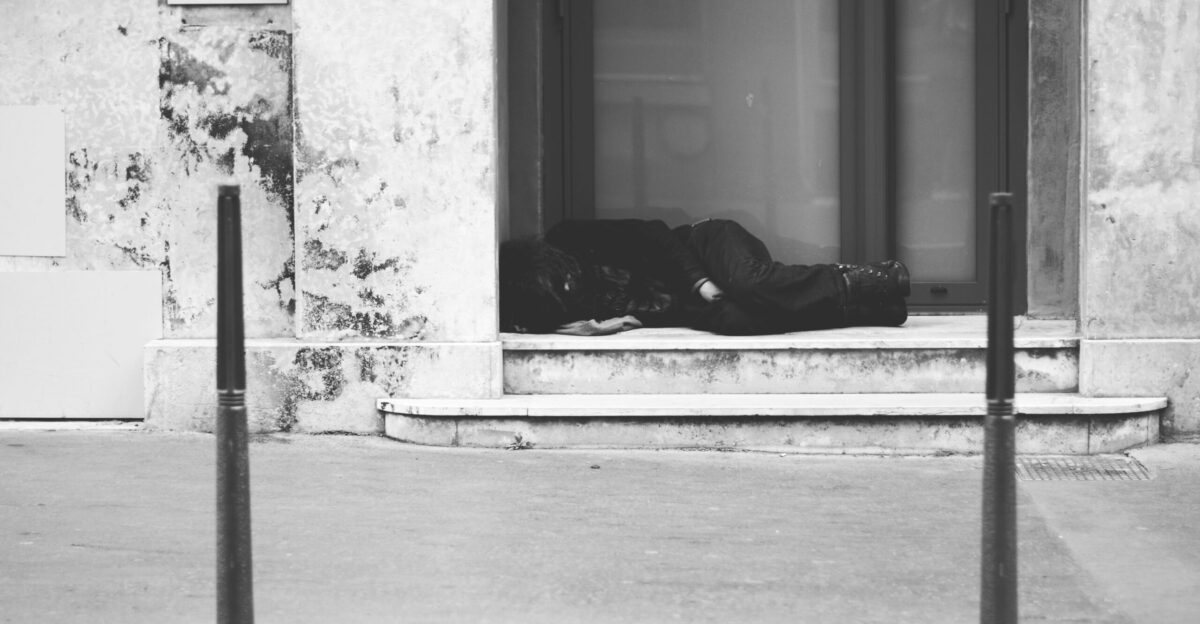 grayscale photo of man lying on floor
