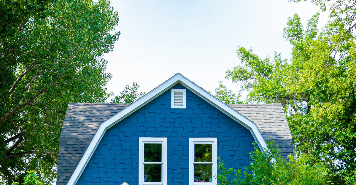 blue and white wooden house near green trees during daytime
