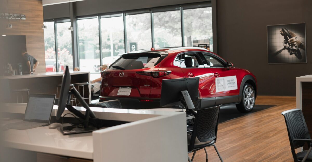 a red car is parked in a showroom