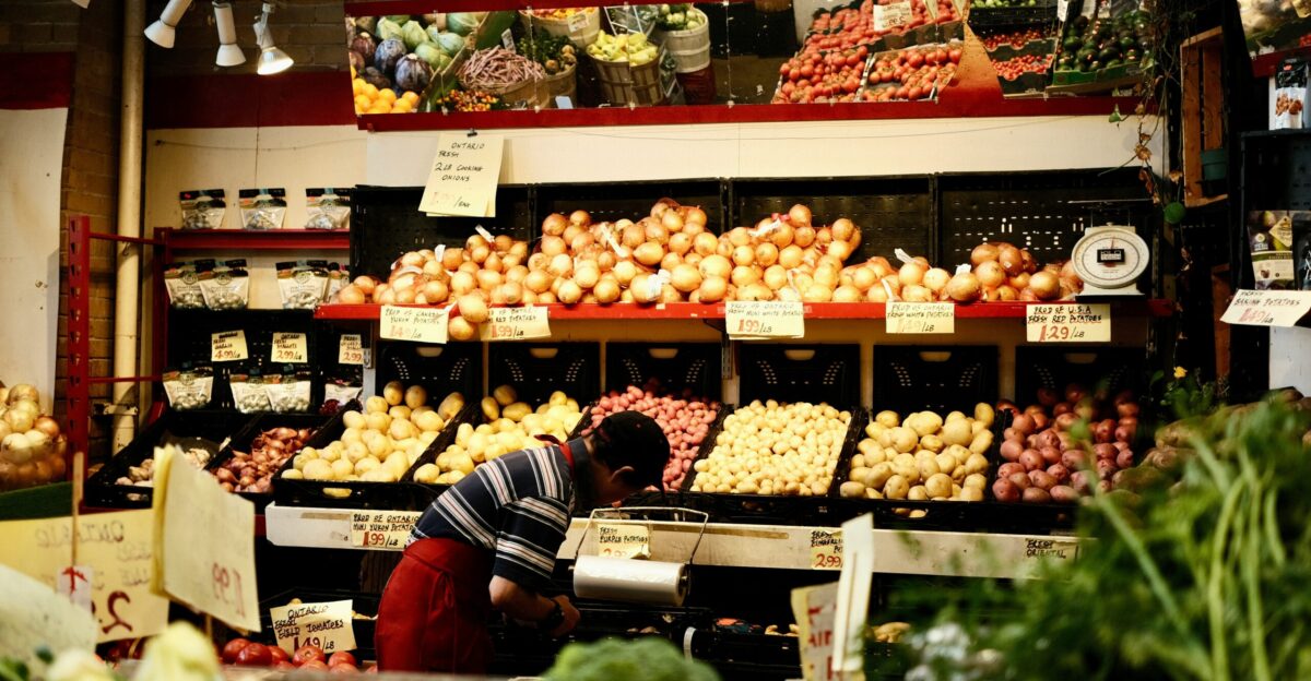 a man standing in front of a display of vegetables