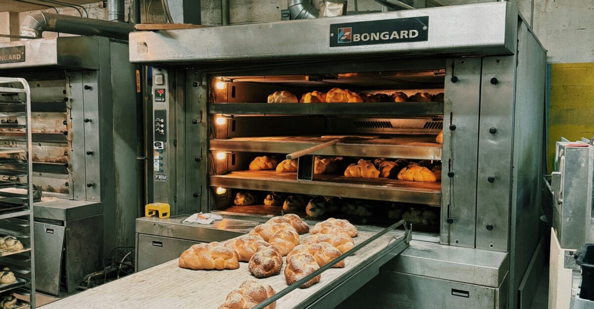 a bakery with a conveyor belt filled with doughnuts