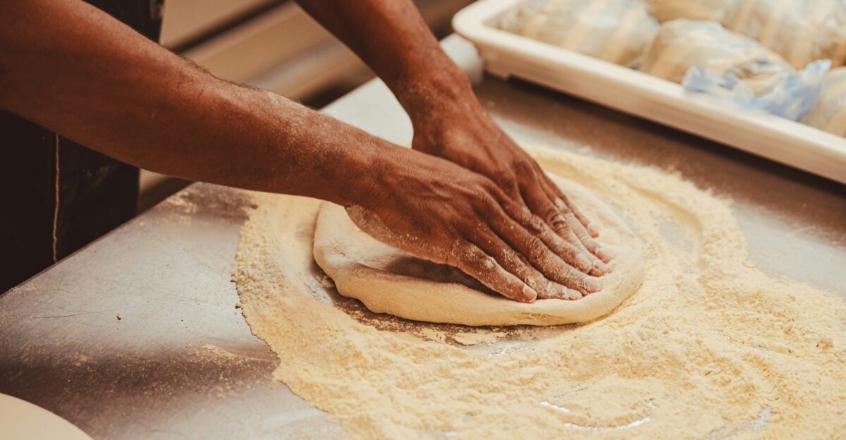 a person kneading dough on top of a table