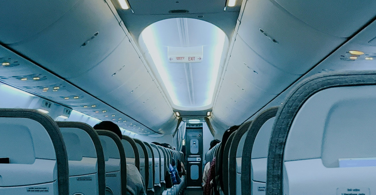 The inside of an airplane with rows of empty seats
