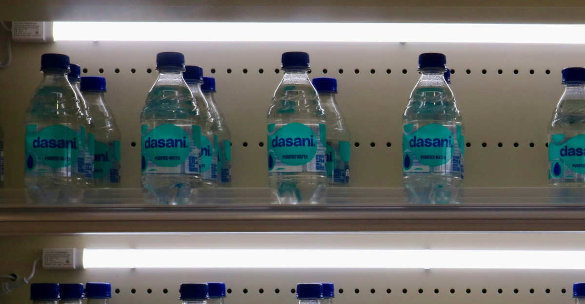 Bottled water is stacked on illuminated shelves