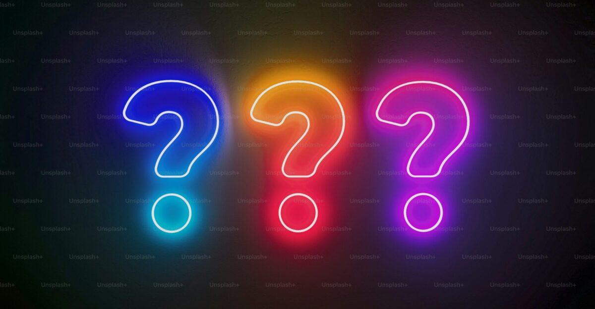 A neon sign with a question mark next to it photo - Wallpaper